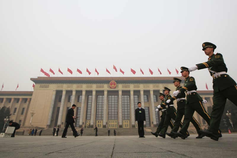 © Reuters. Paramilitary policemen march in front of the Great Hall of the People before delegates arrive for a meeting ahead of the National People's Congress (NPC), in Beijing