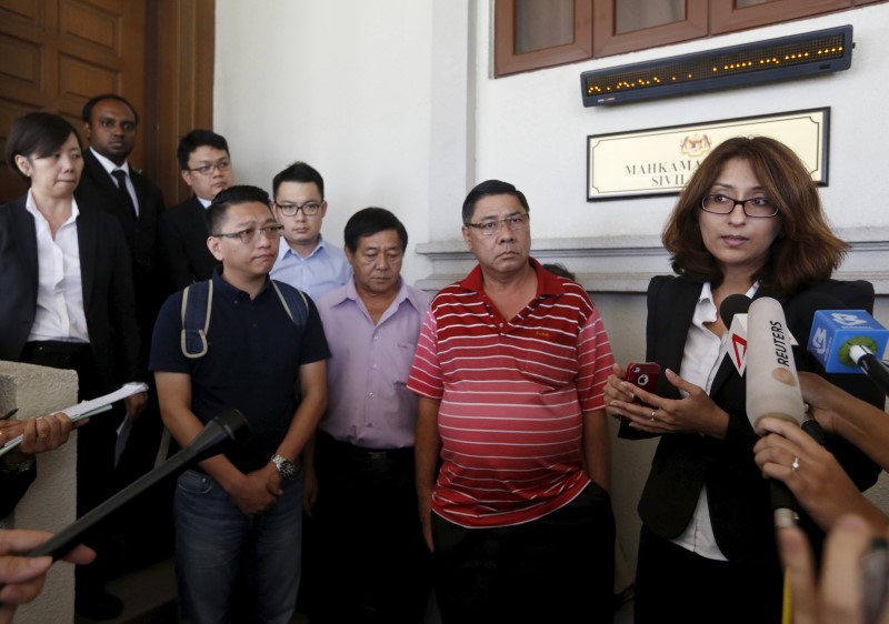 © Reuters. Lawyer Sangeet Deo speaks the media, accompanied by relatives of passengers three passengers aboard the missing Malaysia Airlines flight MH370 during a hearing 