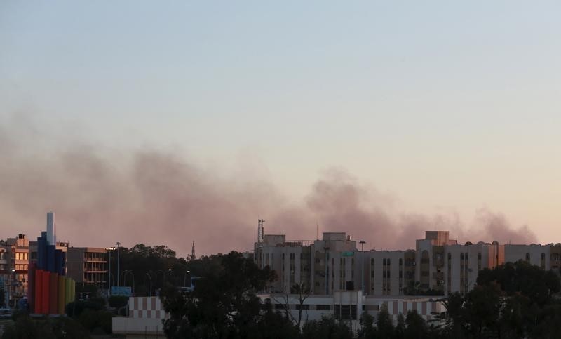 © Reuters. Black smoke billows in the sky above areas where clashes are taking place between pro-government forces, who are backed by the locals, and the Shura Council of Libyan Revolutionaries in Benghazi