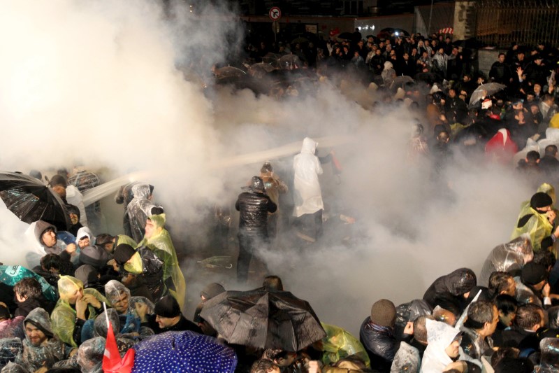 © Reuters. Riot police use tear gas to disperse protesting employees and supporters of Zaman newspaper in front of its headquarters in Istanbul