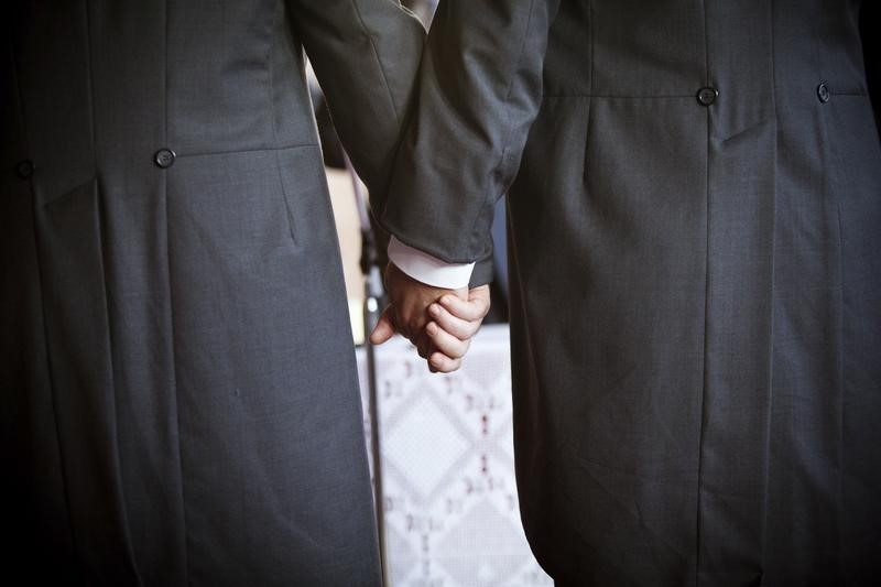 © Reuters. File photo of Australian MP Hunter holding hands with his partner Semmens during their wedding in the town of Jun in southern Spain