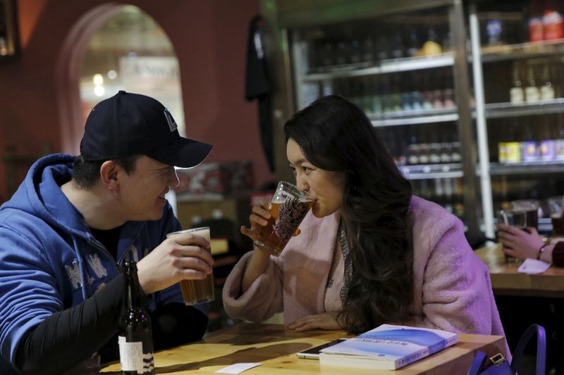 © Reuters. Customer Wang Wenqian and her husband Meng Lu drink craft beer at a microbrewery in Beijing