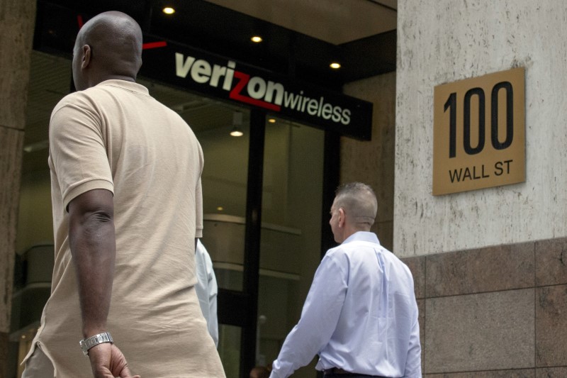 © Reuters. People pass by a Verizon store at 100 Wall St. in New York's financial district 