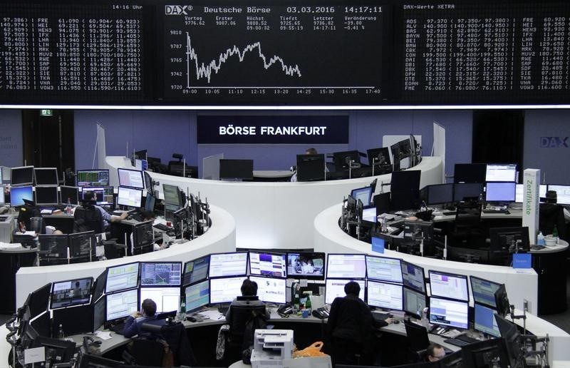 © Reuters. Traders work at their desks in front of the German share price index, DAX board, at the stock exchange in Frankfurt