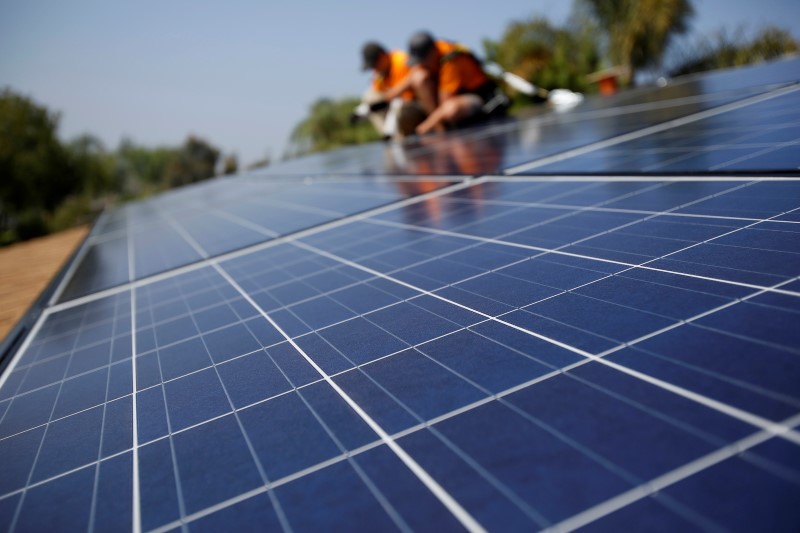 © Reuters. Vivint Solar technicians install solar panels on the roof of a house in Mission Viejo