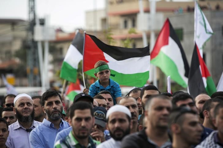 © Reuters. Israeli-Arabs hold Palestinian flags during a pro-Palestinian demonstration in the northern Israeli town of Sakhnin