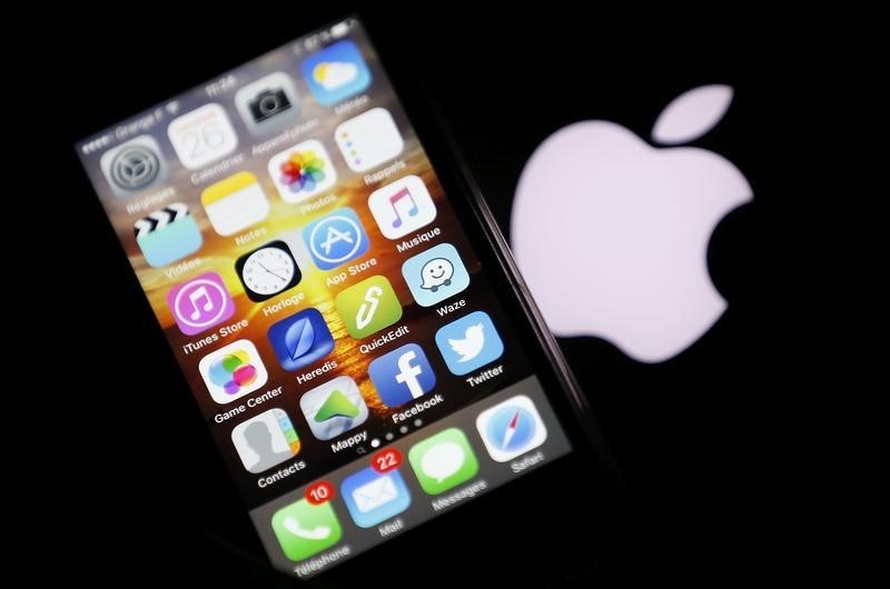 © Reuters. Iphone fotografado ao lado de logo da Apple