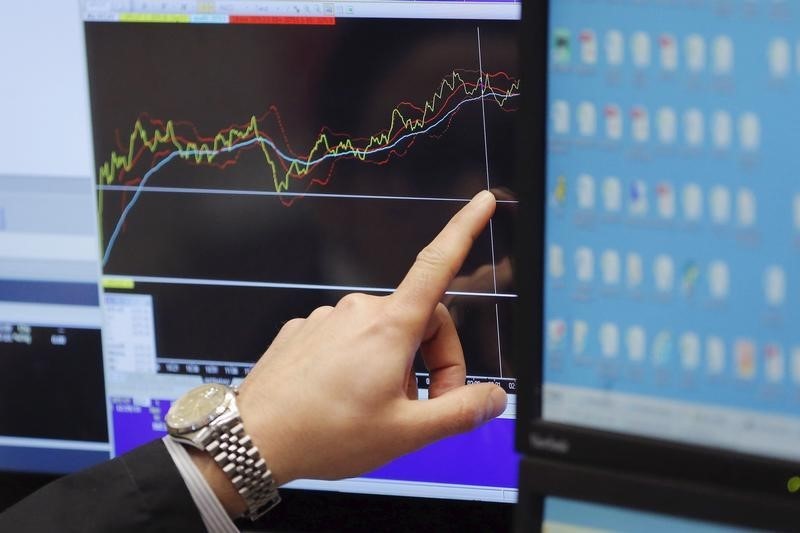 © Reuters. A trader points at a chart on a monitor above the floor of the New York Stock Exchange in New York