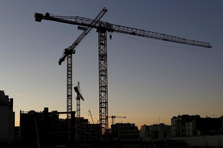© Reuters. Cranes are seen in silhouette at dusk at a building construction site in Paris