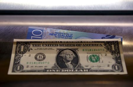 © Reuters. A New Zealand ten dollar note sits underneath a United States one dollar bill in the window of a currency exchange teller in Sydney, Australia