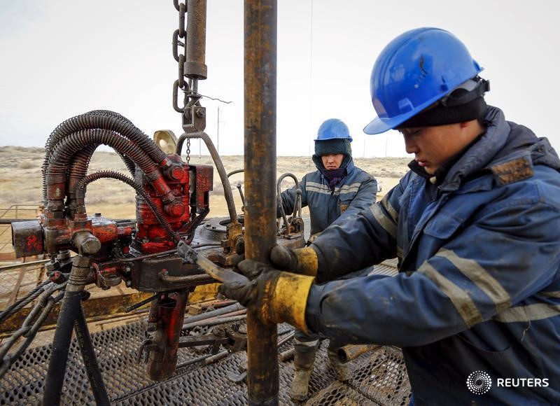 © Reuters. Рабочие проверяют оборудование на нефтяном месторождении РД Казмунайгаз в Кызылординской области Казахстана