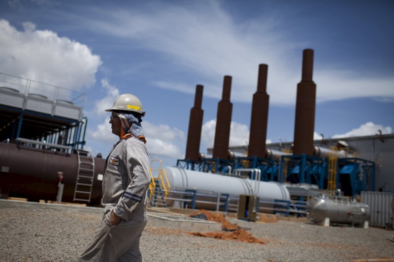 © Reuters. File photo of an oil worker walking past an oil installation operated by Venezuela's state oil company PDVSA in Morichal