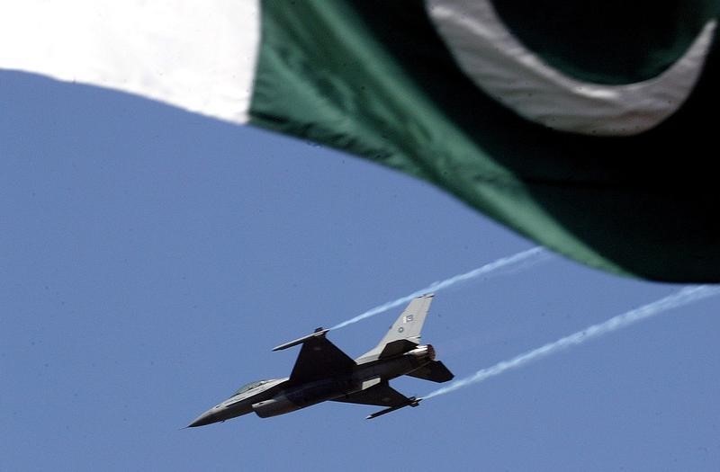 © Reuters. A Pakistani airforce F-16 plane flies over a Pakistani national flag during a full dress rehearsal ...