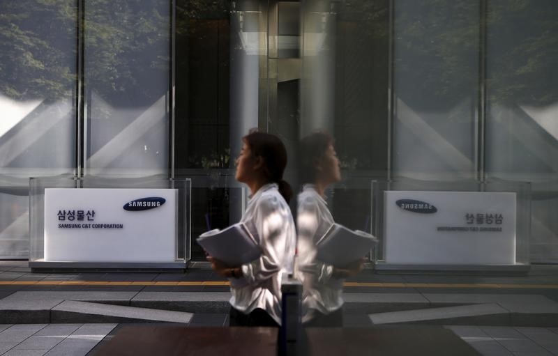 © Reuters. An employee walks past a logo of Samsung C&T Corp at the company's headquarters in Seoul