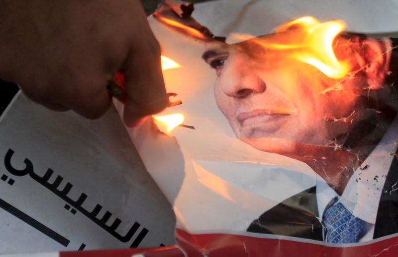 © Reuters. File photo shows a demonstrator burning a poster of then former Egyptian army chief Abdel Fattah al-Sisi during a protest against a law restricting demonstrations near El-Thadiya presidential palace in Cairo