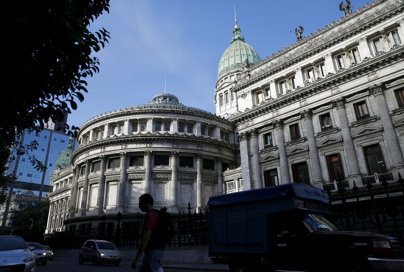 © Reuters. A man crosses the street outside the Argentine Congress in Buenos Aires