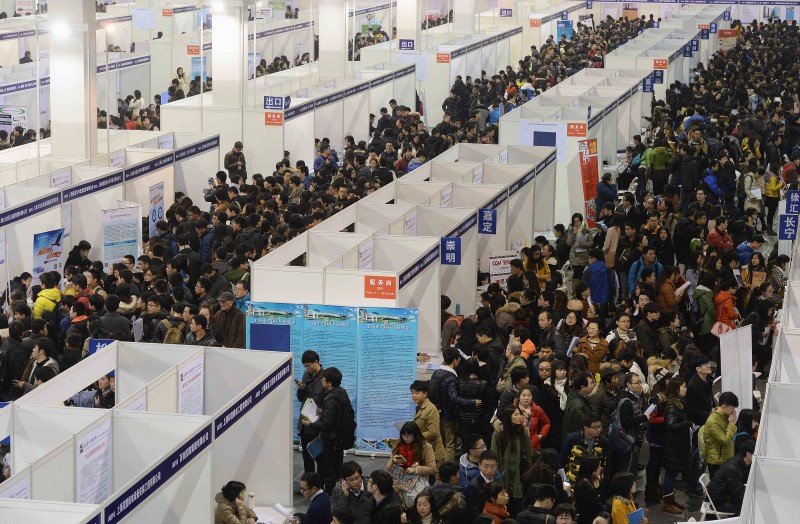 © Reuters. Job seekers visit booth at a job fair in Shanghai