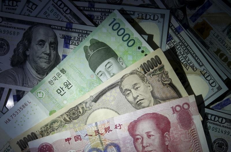 © Reuters. South Korean won, Chinese yuan and Japanese yen notes are seen on U.S. 100 dollar notes in this picture illustration taken in Seoul