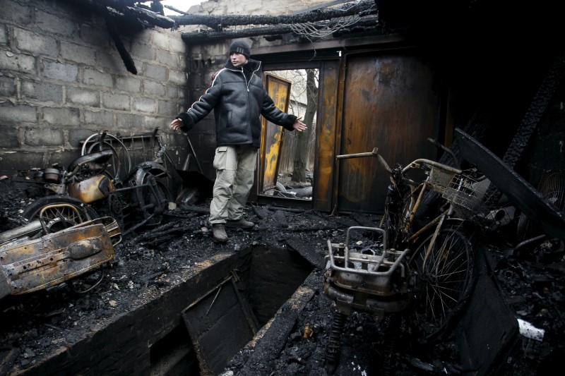 © Reuters. A local resident gestures while standing in his garage, which was damaged during the recent exchange of fire between Ukrainian government forces and Russian-backed separatists, on the outskirts of Donetsk