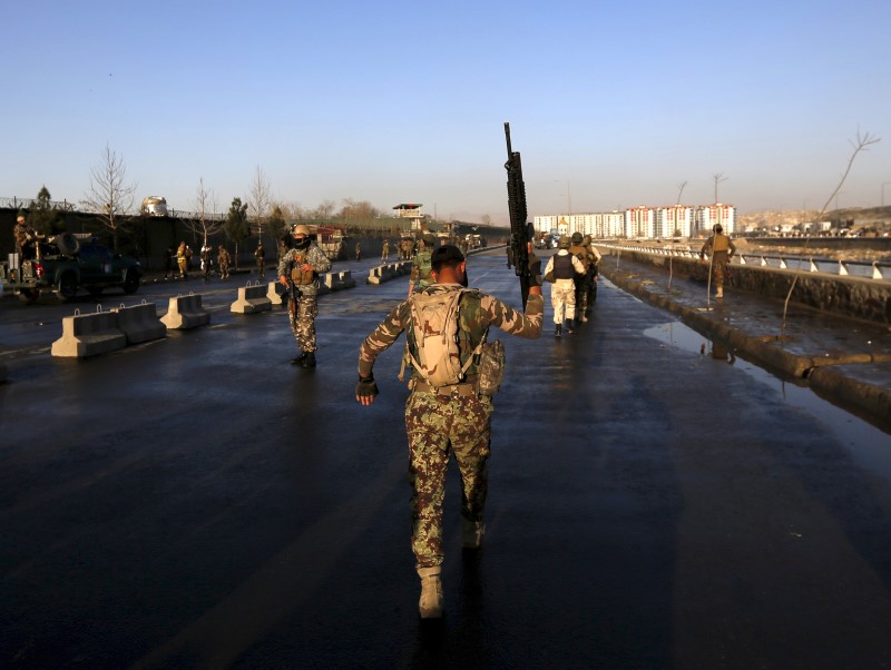 © Reuters. File photo shows a member of Afghan security forces holding up his rifle as he walks at the site of an attack in Kabul