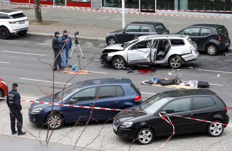 © Reuters. Police inspect the scene of a damaged Volkswagen car in the Bismarckstrasse in Berlin