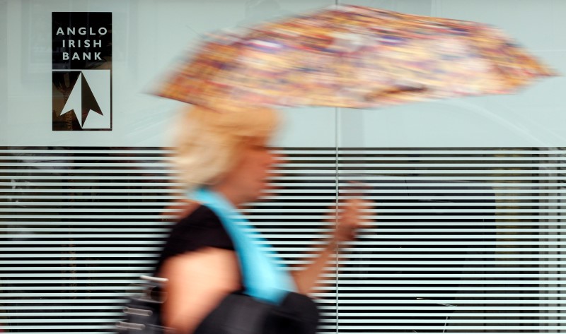 © Reuters. File photograph shows a woman walking past a branch of the Anglo Irish Bank in Belfast