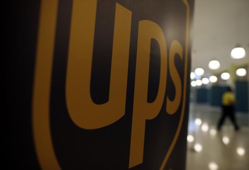 © Reuters. UPS employee walks past a sign bearing the company's logo at a job fair in Chicago