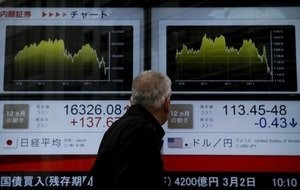 © Reuters. A man looks at an electronic board outside a brokerage in Tokyo