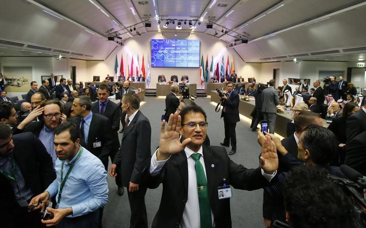 © Reuters. Security staff pushes back the media during the start of a meeting of OPEC oil ministers in Vienna