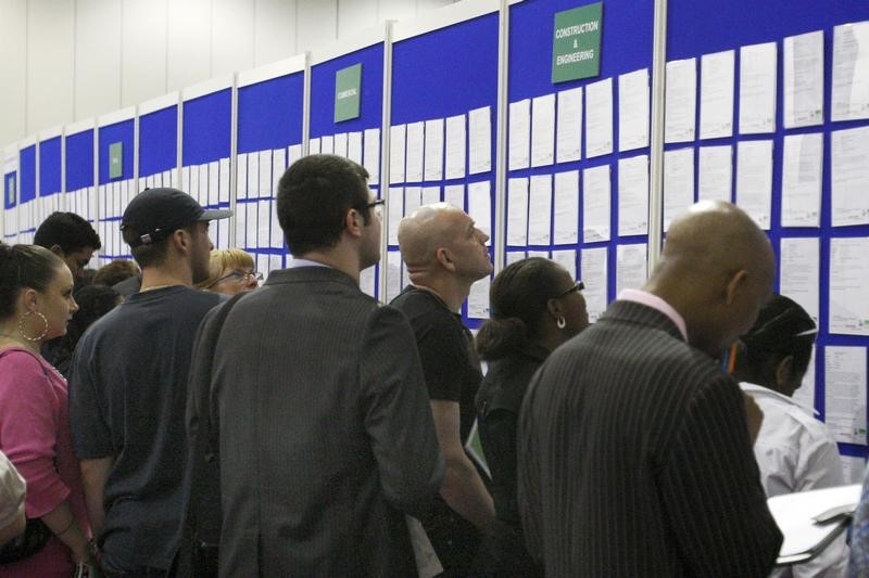 © Reuters. File photo of people look at job listings at the Careers and Jobs Live careers fair at the ExCeL centre in London April 19, 2009.