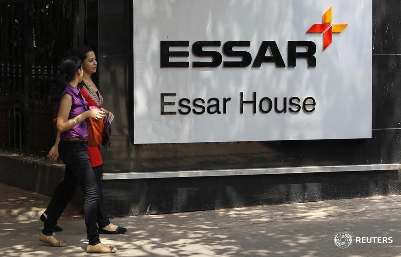 © Reuters. Сотрудники проходят мимо логотипа Essar Group у штаб-квартиры компании в Мумбаи