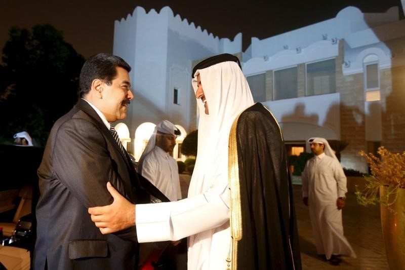 © Reuters. Venezuela's President Nicolas Maduro shakes hands with the Emir of Qatar, Tamim bin Hamad al-Thani in this handout picture provided by Miraflores Palace
