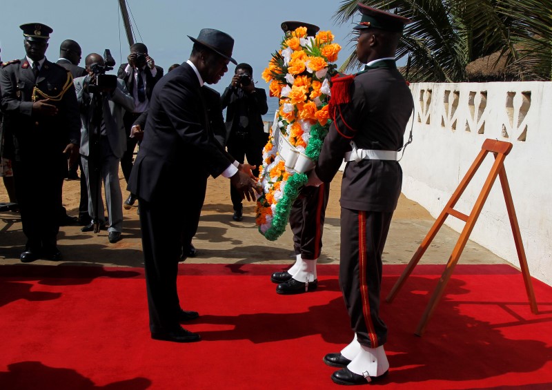 © Reuters. Ivory Coast's President Alassane Ouattara prepares to lay a wreath for those killed in Sunday's attack by Al Qaeda in the Islamic Maghreb, on a beach in Grand Bassam