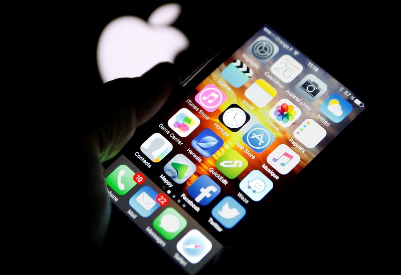 © Reuters. An Apple iPhone is pictured next to the logo of Apple in Bordeaux, southwestern France, February  26, 2016. REUTERS/Regis Duvignau  