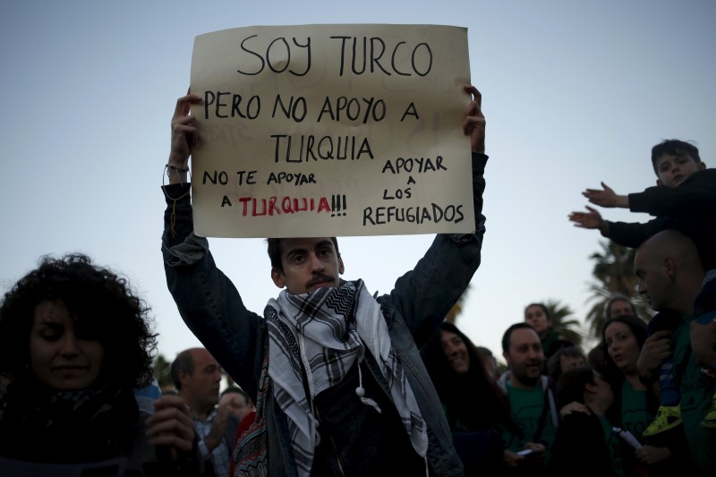 © Reuters. Serdar Ocaksonmez, a Turk living in Malaga, holds a sign during a protest against the EU-Turkey migrant deal in Malaga