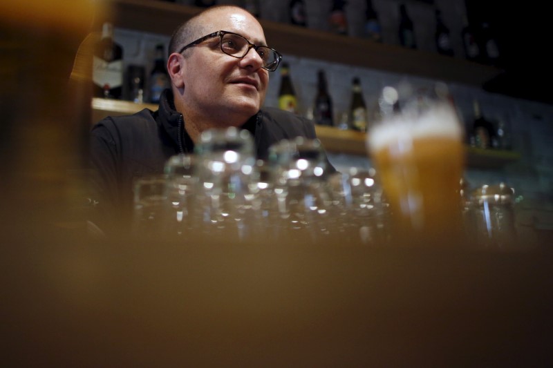 © Reuters. Beer Shooter franchise manager Ricardo Gil serves a glass of beer at the imported and locally-brewed craft beer shop in Madrid