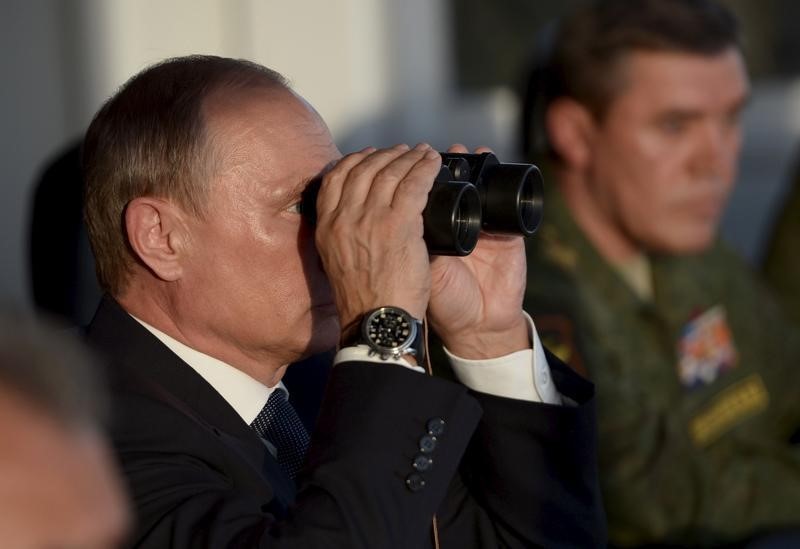 © Reuters. Russian President Vladimir Putin uses a pair of binoculars to observe troops in action during a training exercise at the Donguz testing range in Orenburg region, Russia