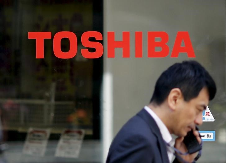 © Reuters. Homem passa em frente a fachada com logo da Toshiba