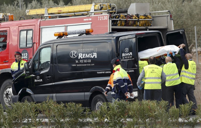 © Reuters. Funeral workers put a stretcher bearing a body into a hearse after a traffic crash in Freginals