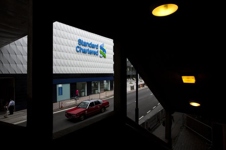 © Reuters. Taxi drives past Standard Chartered's main branch in Hong Kong