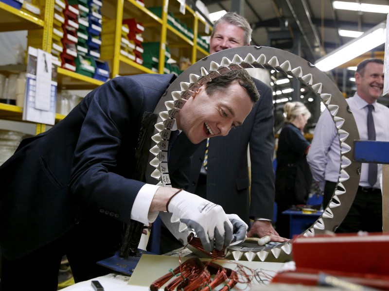 © Reuters. Britain's Chancellor of the Exchequer Osborne works on a component during a visit to a generator manufacturer in Leeds