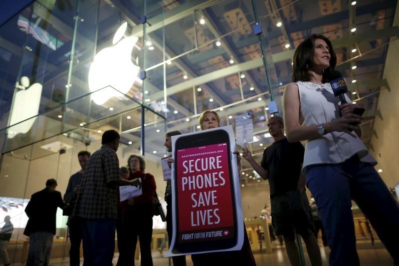 © Reuters. People gather at a small rally in support of Apple's refusal to help the FBI access the cell phone of a gunman involved in the killings of 14 people in San Bernardino, in Santa Monica