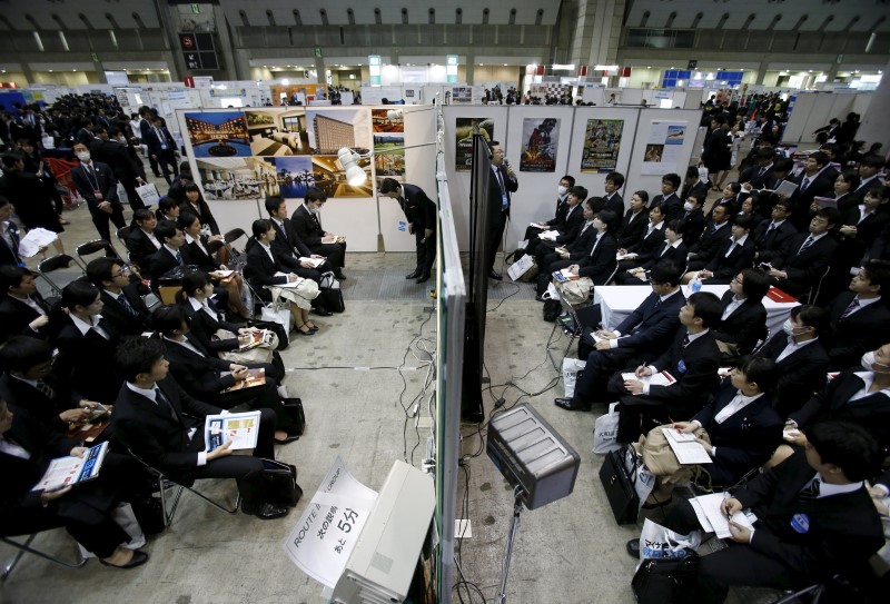 © Reuters. Job seekers attend orientation sessions at company booths during a job fair held for fresh graduates in Tokyo