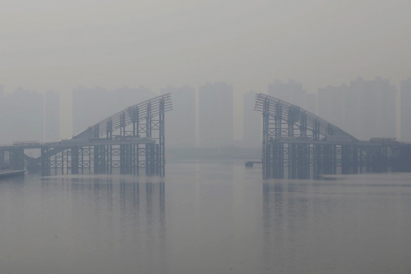 © Reuters. File photo of buildings behind an unfinished bridge near the Yujiapu financial centre