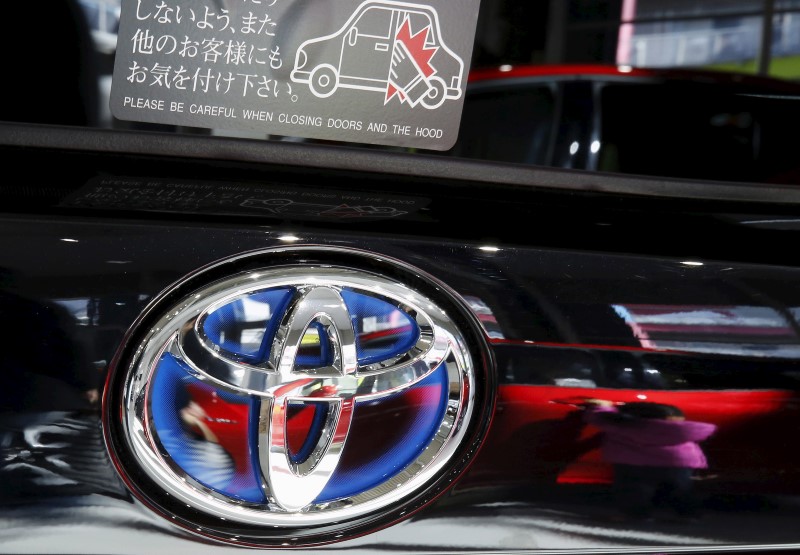 © Reuters. A visitor is reflected on a Toyota Motor Corp's Prius hybrid car at the company's showroom in Tokyo