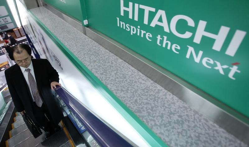 © Reuters. A shopper rides an escalator past a logo of Hitachi Corp at an electronics retail store in Tokyo