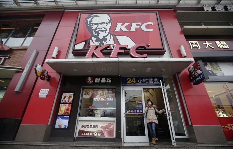 © Reuters. A woman walks out from a KFC restaurant as she speaks on her mobile phone in Wuhan