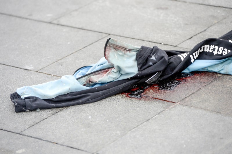 © Reuters. Blood is covered with a jacket outside the terminal at Brussels national airport during a ceremony following bomb attacks in Brussels metro and Belgium's National airport of Zaventem