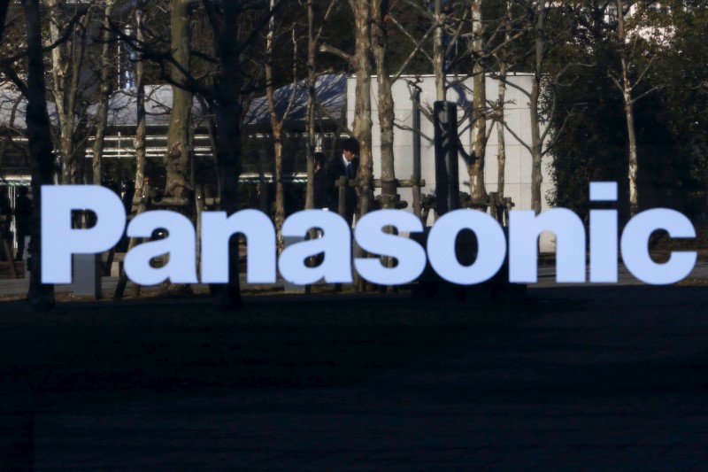 © Reuters. A pedestrian is reflected in a sign at Panasonic Center in Tokyo