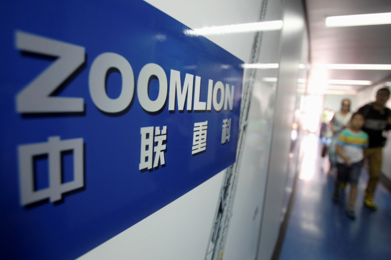 © Reuters. A Zoomlion company logo is seen on an advertisement as passengers walk past at an airport in Changsha